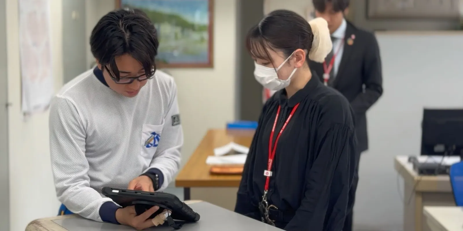 タブレットで受付業務を行うスタッフ